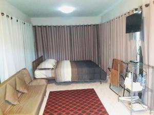Thanorm Rak Resort في كاو كو: غرفة معيشة مع أريكة وسرير