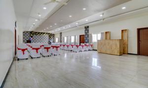 a large banquet hall with red and white chairs and tables at Treebo Trend Orchid in Chikmagalūr