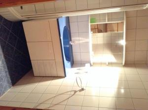 a bathroom with a white floor and a chair in a room at Haus Pock Apartments in Lake Pressegg