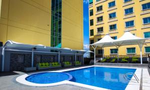 una piscina di fronte a un edificio di The Royal Mandaya Hotel a Davao