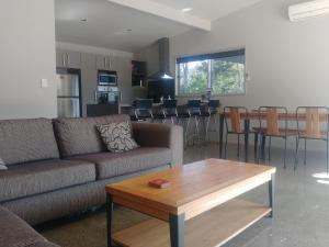 a living room with a couch and a table at Ryder Ridge Holiday Home in Motueka