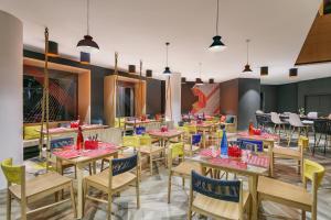 une salle à manger avec des tables et des chaises en bois dans l'établissement Ginger Goa, Panjim, à Panaji