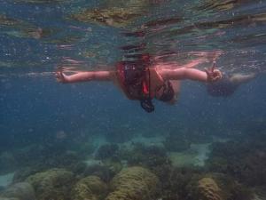 een vrouw drijvend in het water boven een rif bij Lung Pod 9 resort in Chumphon