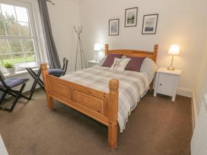 a bedroom with a bed and a table and a window at 79 Laurel Bank in Gatehouse of Fleet