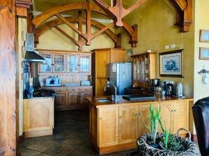 a kitchen with wooden cabinets and a refrigerator at Beachfront House in Great Brak River
