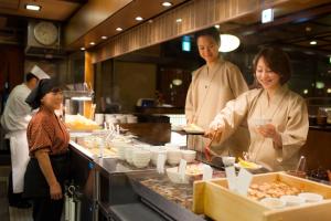 three chefs preparing food in a restaurant kitchen at Takayama Ouan in Takayama