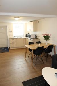 a living room with a table and chairs and a kitchen at Odense Apartments in Odense