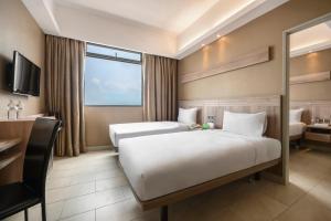 ein Hotelzimmer mit 2 Betten und einem TV in der Unterkunft Cititel Express Penang in George Town