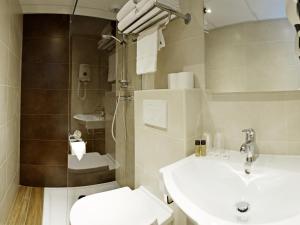 a bathroom with a sink, toilet and bathtub at Hôtel Esprit d'Azur in Nice