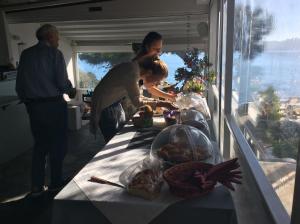 a woman standing next to a table with food on it at Rosys Little Village in Skala
