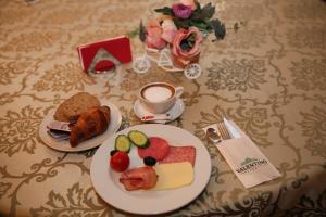 Valentino Rooms في فوكشاني: طاولة مع طبقين من الطعام وكوب من القهوة