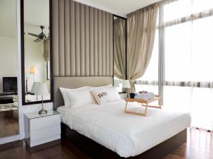 a bedroom with a large white bed with a window at Ken Bangsar By Sleepy Bear in Kuala Lumpur