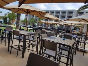 an outdoor restaurant with tables and chairs and umbrellas at Royal Thalassa Monastir in Monastir