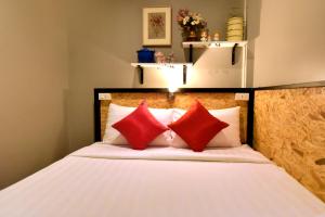 - une chambre avec un lit et des oreillers rouges dans l'établissement OK CHIC PHUKET HOSTEL, à Phuket