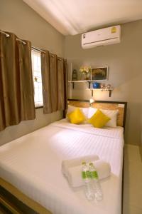 ein Schlafzimmer mit einem Bett mit zwei Handtüchern darauf in der Unterkunft OK CHIC PHUKET HOSTEL in Phuket