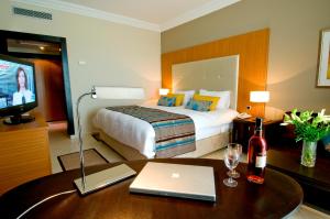a hotel room with a bed and a desk with a laptop at Royal Thalassa Monastir in Monastir