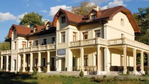 una grande casa bianca con il tetto marrone di Hotel Hercegovina a Sarajevo