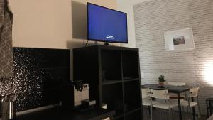 a flat screen tv on top of a black entertainment center at Benvenuto Apartman in Budapest