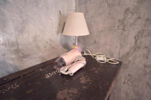una mesa con una lámpara y un teléfono. en OK CHIC PHUKET HOSTEL en Phuket