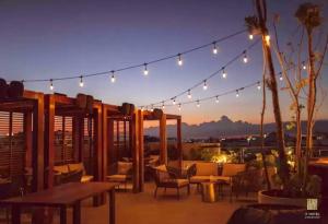 un patio en la azotea con luces, mesas y sillas en It Residence Top Location Luxury 2 Br Two Roof Pools Beach Club included, en Playa del Carmen