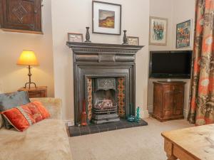 a living room with a fireplace and a tv at Fox Cottage in Carnforth