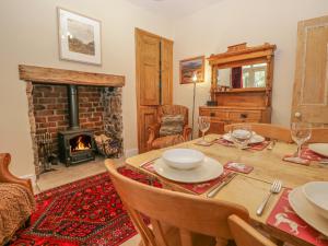a dining room with a table and a fireplace at Fox Cottage in Carnforth