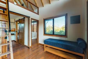 a living room with a blue couch and a window at Inn The Trees Cabañas in Placencia