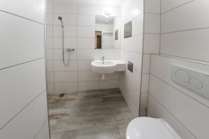 a white bathroom with a toilet and a sink at City Hotel in Banská Bystrica