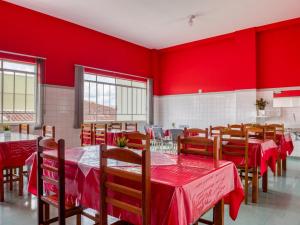 a restaurant with red walls and wooden tables and chairs at Palace Hotel Itapira in Itapira