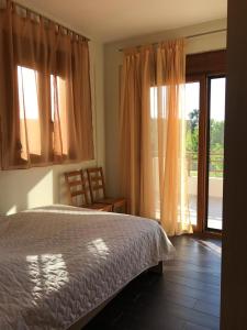 a bedroom with a bed and a sliding glass door at Villa Dimitrios in Kriopigi