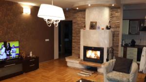 a living room with a fireplace and a tv at Vila Sani in Sarajevo