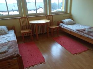 a room with two beds and a table and chairs at OSiR w Człuchowie in Człuchów