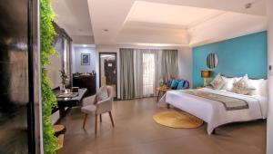 シェムリアップにあるSokchea Angkor Hotelのベッド、デスク、椅子が備わるホテルルームです。