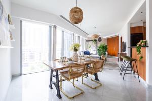 a kitchen and dining room with a wooden table and chairs at Frank Porter - Central Park Towers in Dubai