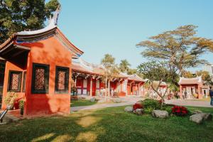 台南的住宿－樹舍包棟民宿開山館，一座橙色的建筑,屋顶在公园里