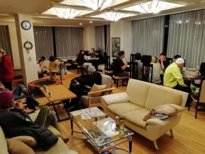 a group of people sitting in a living room at K's House Hakuba Alps - Travelers Hostel in Hakuba