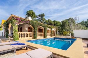 a villa with a swimming pool and a house at Villa Can Odile By SunVillas Mallorca in Cala de Sant Vicent