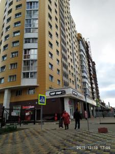 two people walking down a street in front of tall buildings at Новая двухкомнатная квартира в центре Воронежа. in Voronezh