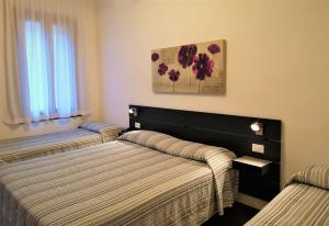 1 dormitorio con 2 camas y un cuadro en la pared en Hotel Rossi, en Venecia