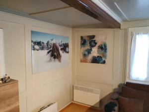 ein Wohnzimmer mit zwei Bildern an der Wand in der Unterkunft Chalet-Etage mitten im Dorf von Leukerbad in Leukerbad