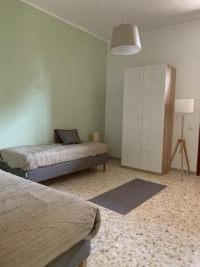 een slaapkamer met 2 bedden en een witte kast bij BnB Nonna Maria in Poggiomarino