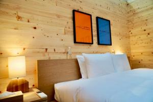 sypialnia z łóżkiem i 2 zdjęciami na ścianie w obiekcie AandA Liam Fuji w mieście Okayama