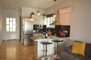 cocina con barra con taburetes y sofá en Sunrise View Apartments en Barbati