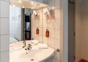 a bathroom with a sink and a mirror at Home Hotel Park in Halden +43 photos