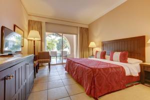 um quarto de hotel com uma cama e uma televisão em TUI MAGIC LIFE Kalawy em Hurghada