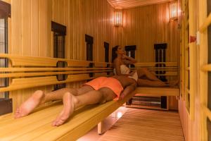 twee personen op banken in een sauna bij Hotel Tiski Cvet in Novi Bečej