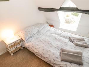 Schlafzimmer mit einem Bett und einem Fenster in der Unterkunft Bron Heulog Cottage in Llangoed