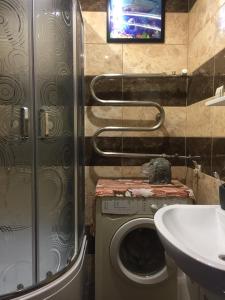 Un baño con lavadora y lavabo. en Хостел Мансардная комната с невысоким потолком до 170 см, en Truskavets