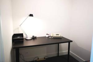 a desk with a printer and a lamp on it at Modern apartment+office w Parking @ Olympic Park in Sydney