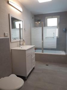 y baño con lavabo, aseo y bañera. en King David breathtaking LAKE VIEW 4BDR PENTHOUSE en Tiberias